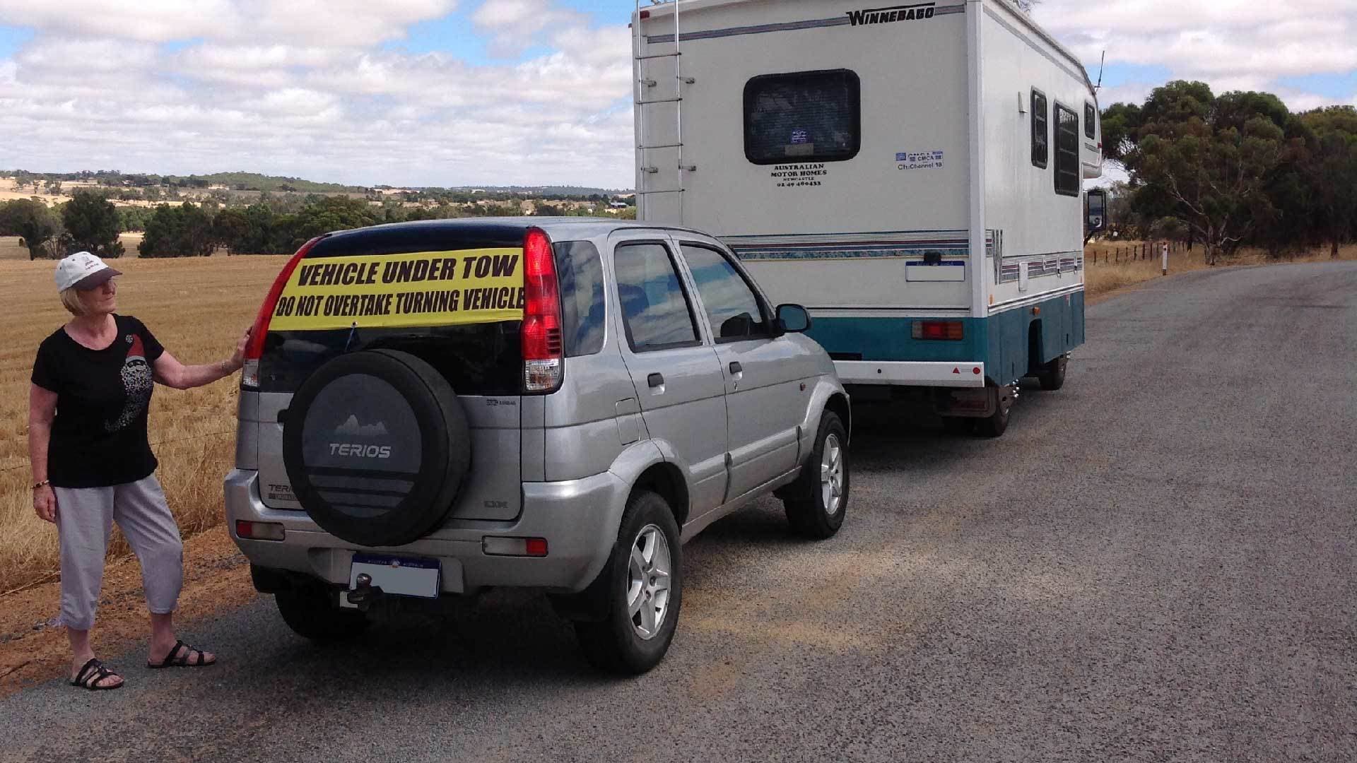 Tow Smart universal vehicle under tow sign on the outside of a towed vehicle rear window